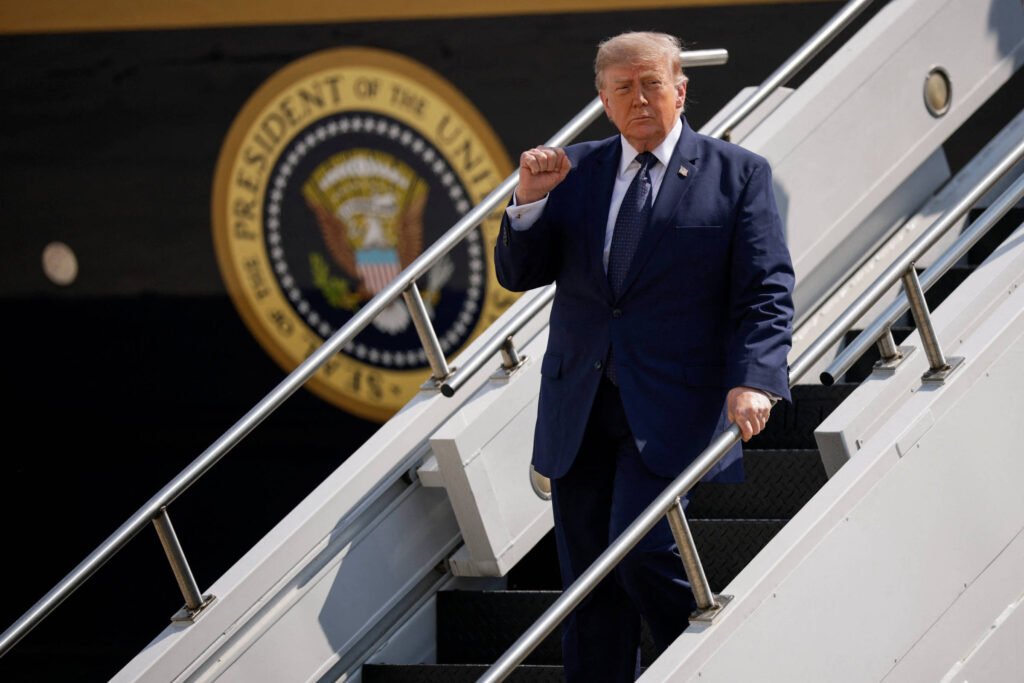 Trump deixou a Turquia em operação secreta após ameaça Homem de terno azul escuro desce escada de avião presidencial branco, com selo presidencial dos Estados Unidos visível ao fundo.